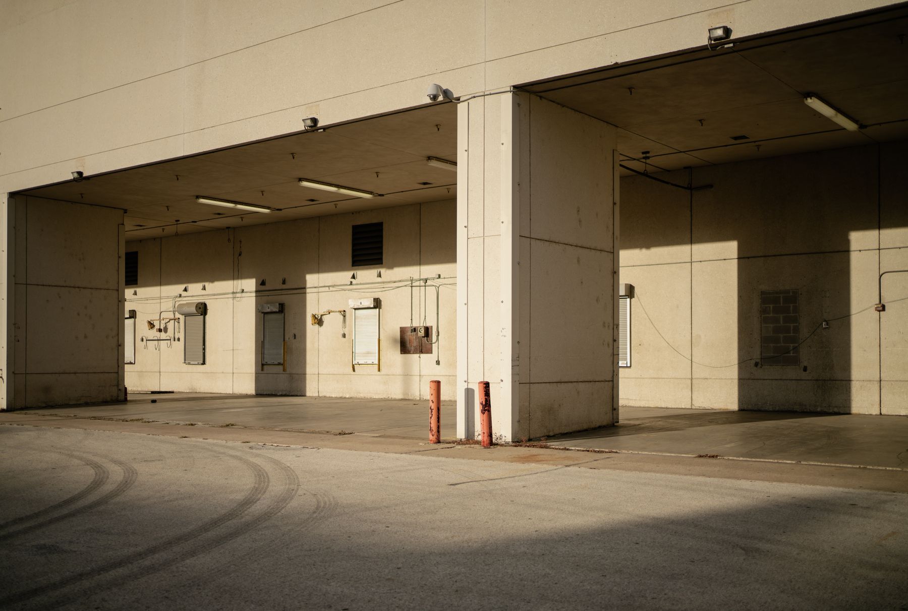 Sunlit industrial warehouse loading area with metal dock doors